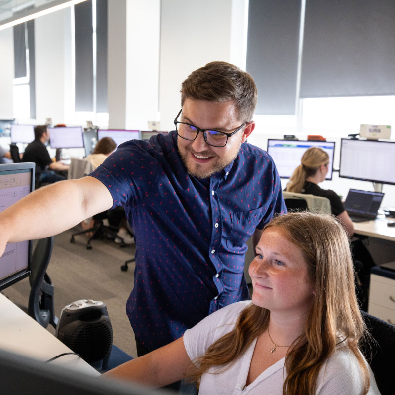 Two Echo employees working together at desktop.