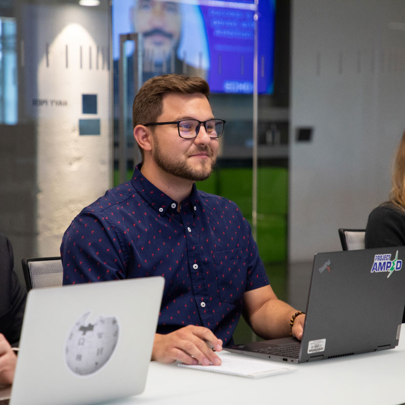 Three Echo employees sitting in a row during a conference room meeting.