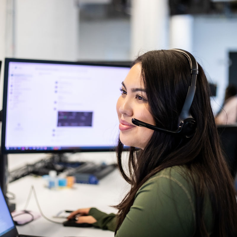 An Echo employee working on their computer with a headset on.