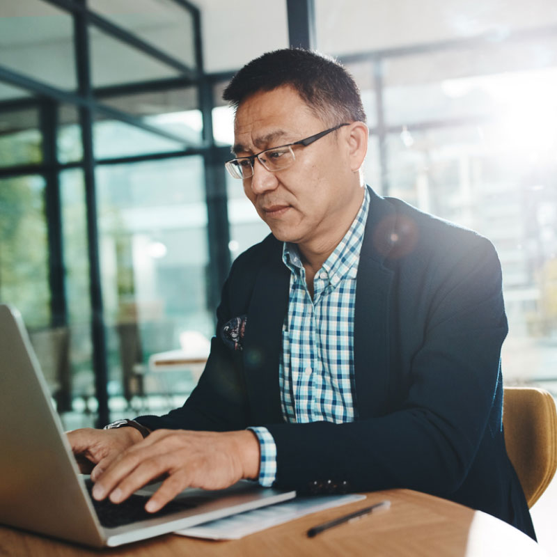 A managed transportation client working on a laptop inside an office space.