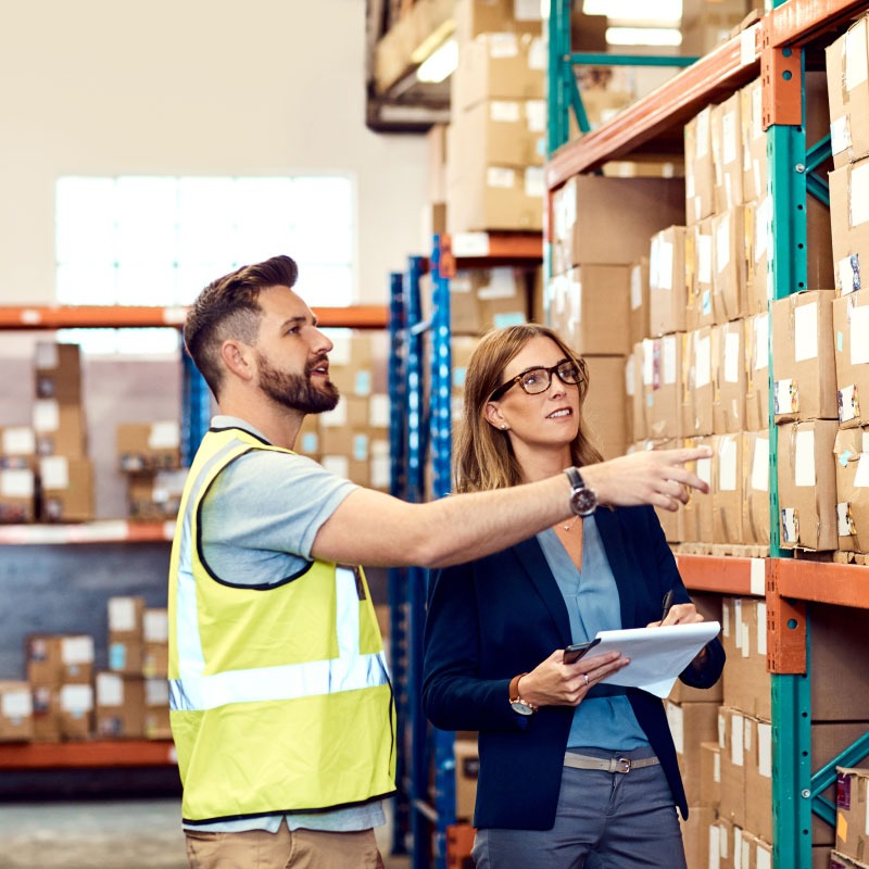 Two warehouse employees conversing over inventory.