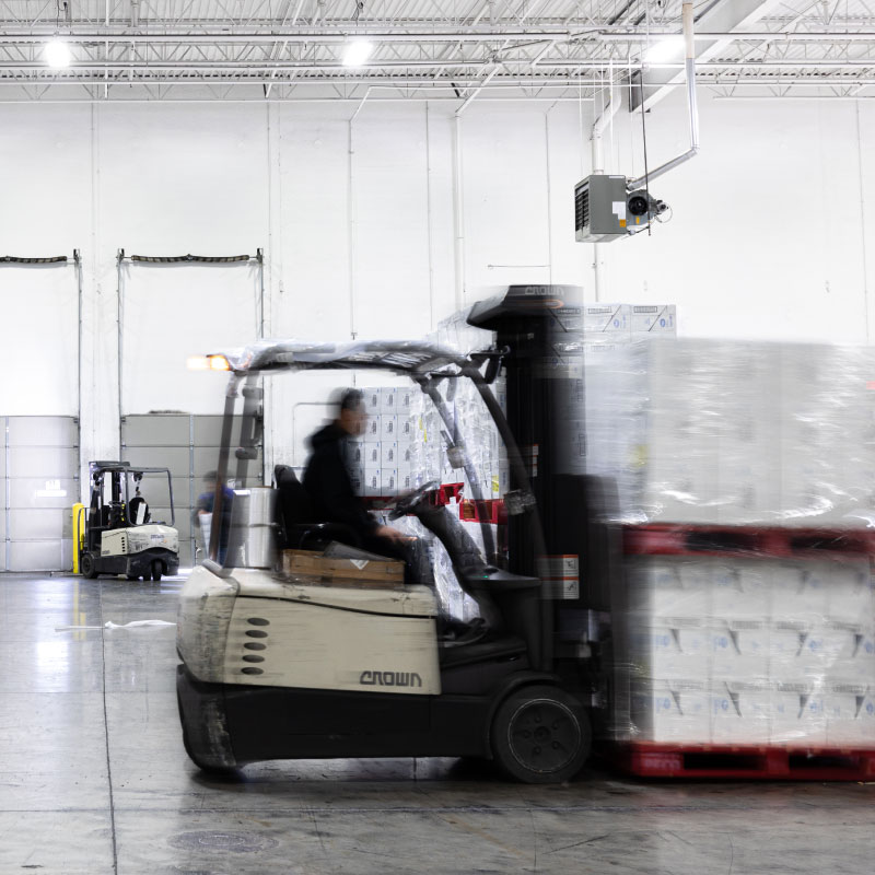 Blurred people moving around warehouse managing shipments.