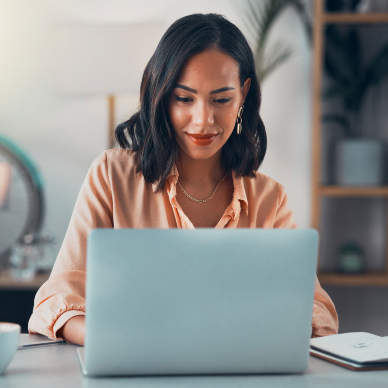 Shipping client sitting at the desk of their home office on their work computer.