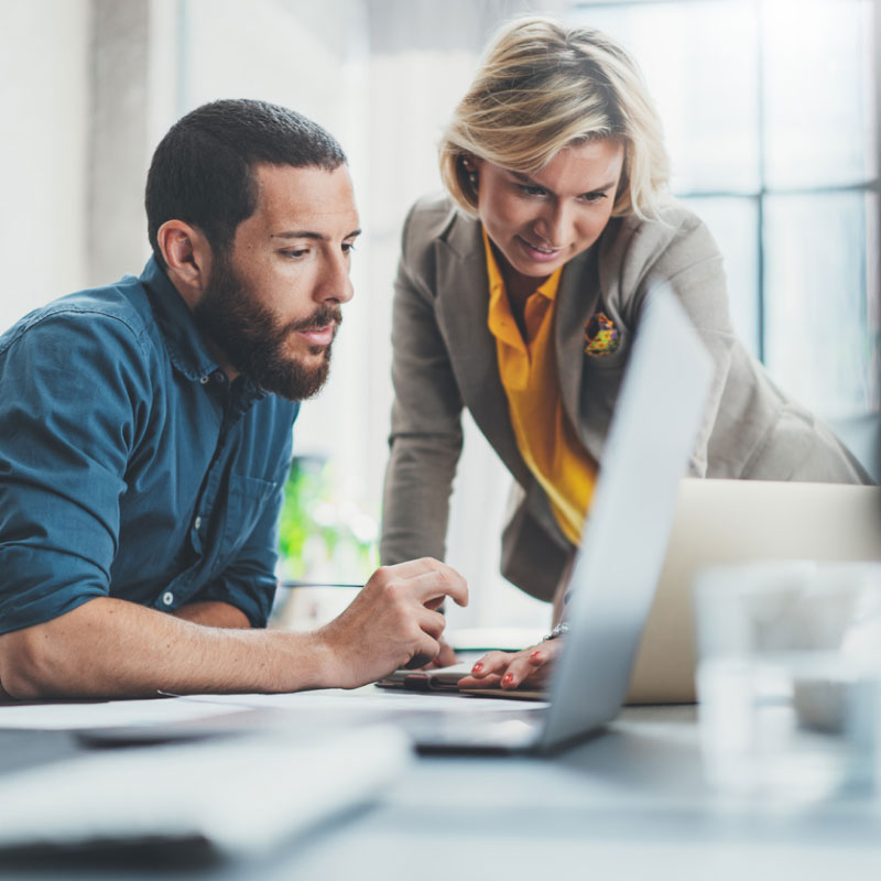 Two shippers in a corporate setting looking at the best mode to use to book their upcoming shipments.