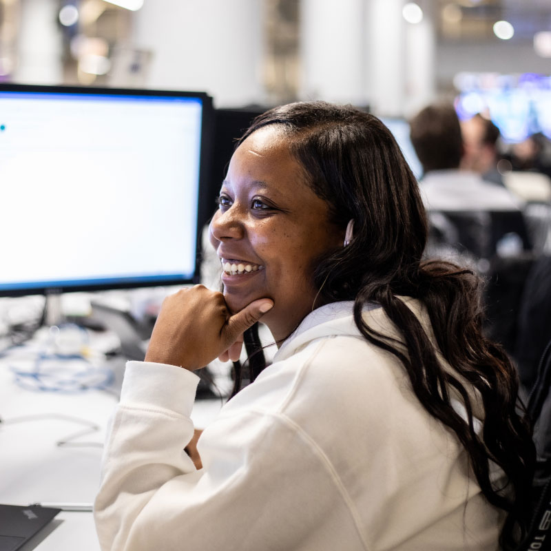 A smiling Echo employee working on her computer at the office.