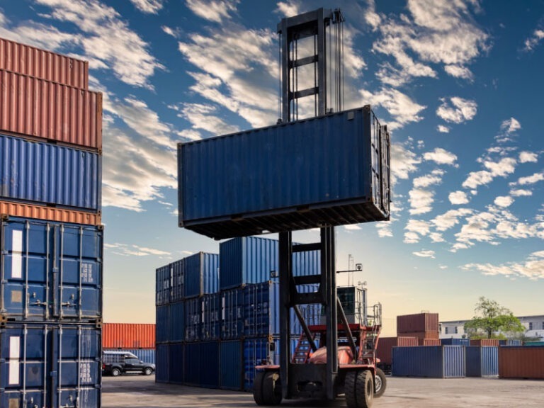 Shipping container being moved by a forklift.