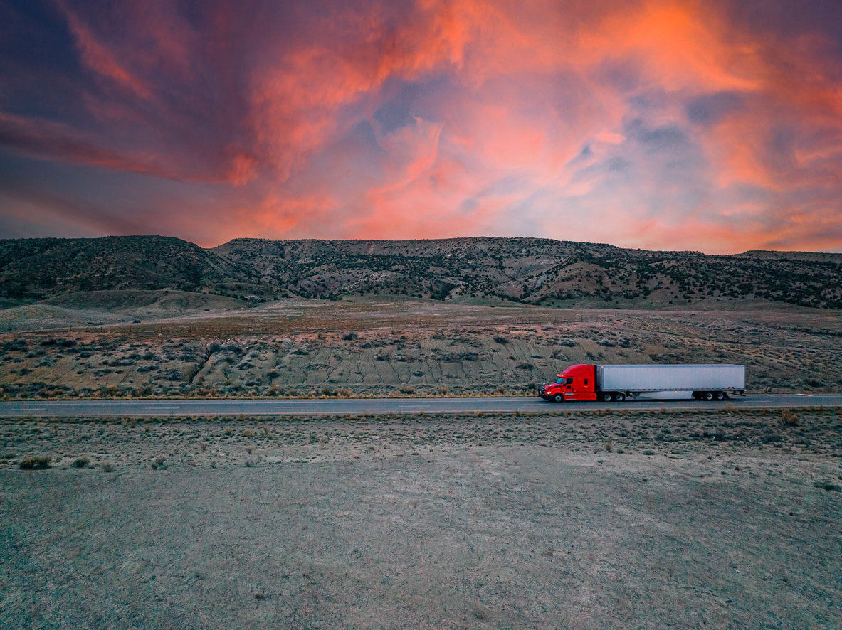 Red semi truck driving across the border in Mexico.