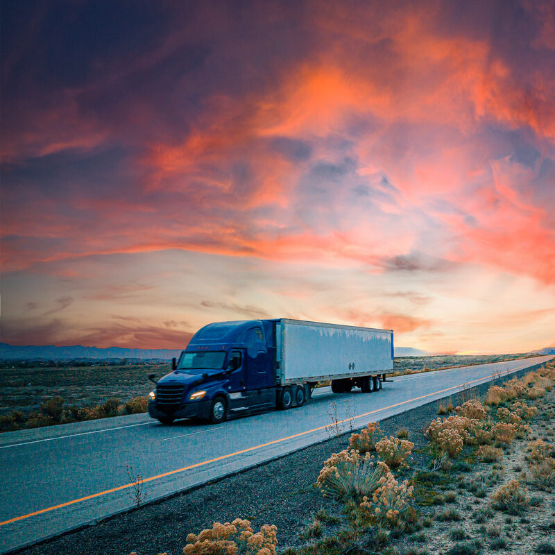 Blue semi truck driving across the border in Mexico.