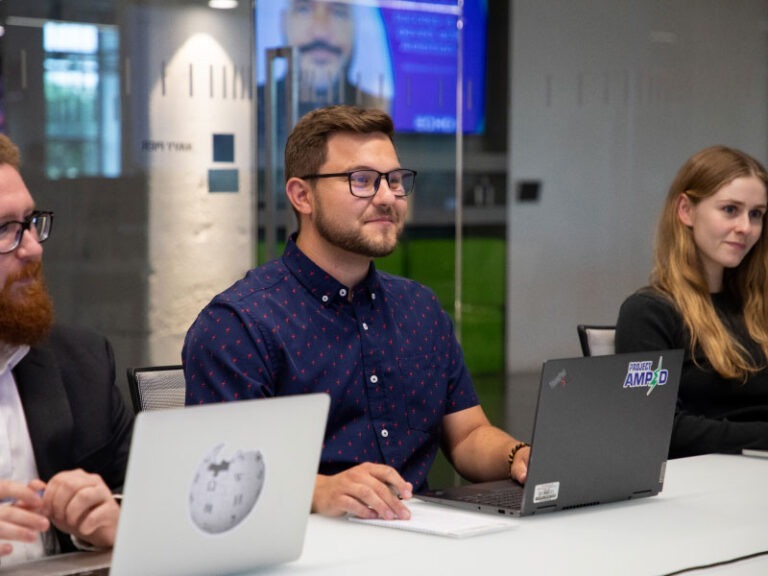 Three Echo employees brainstorming during teamworking session.