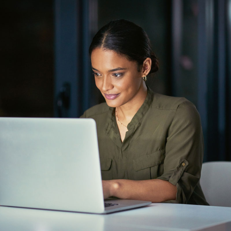 A freight shipper in her office working on her laptop.