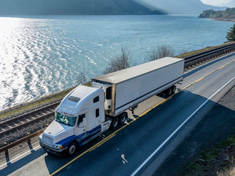 A refrigerated semi truck transporting cargo along the Columbia River.