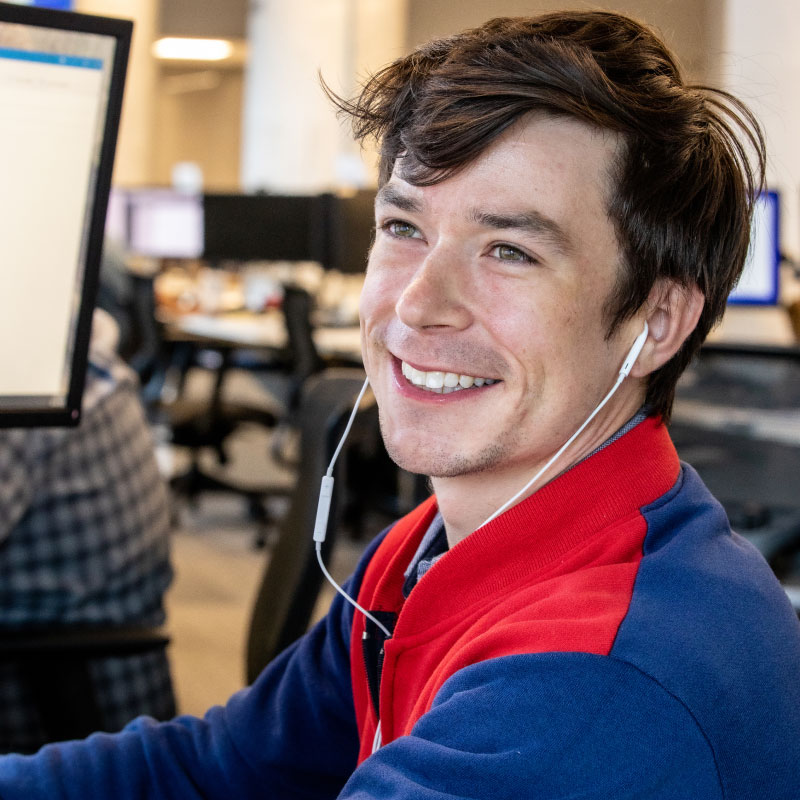 An Echo employee smiling at their desk as they simplify a client's intermodal shipping.