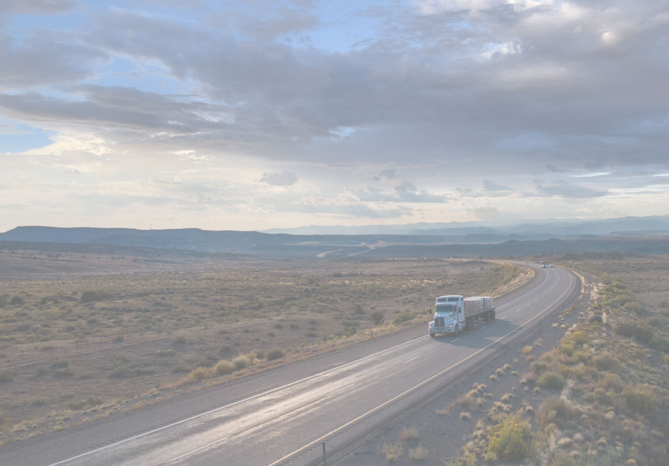 A white semi truck driving down a highway.