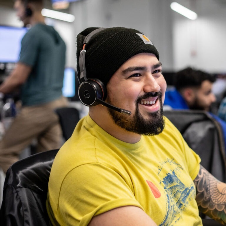 An Echo employee happily works at their desk to offer their client a small parcel shipping solution.