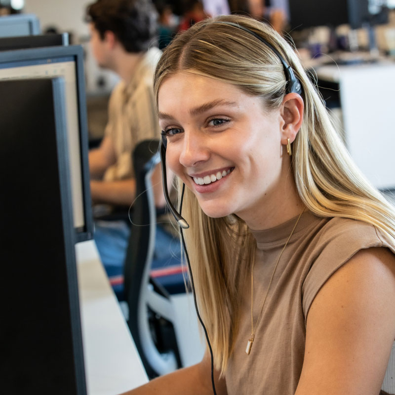 An Echo employee smiling while working on their computer at their desk.