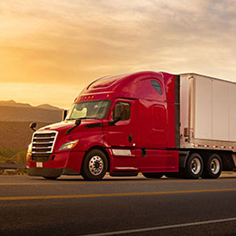 A red semi truck with a temperature controlled truck bed featuring Roadtex, an Echo company, logo driving down a highway.