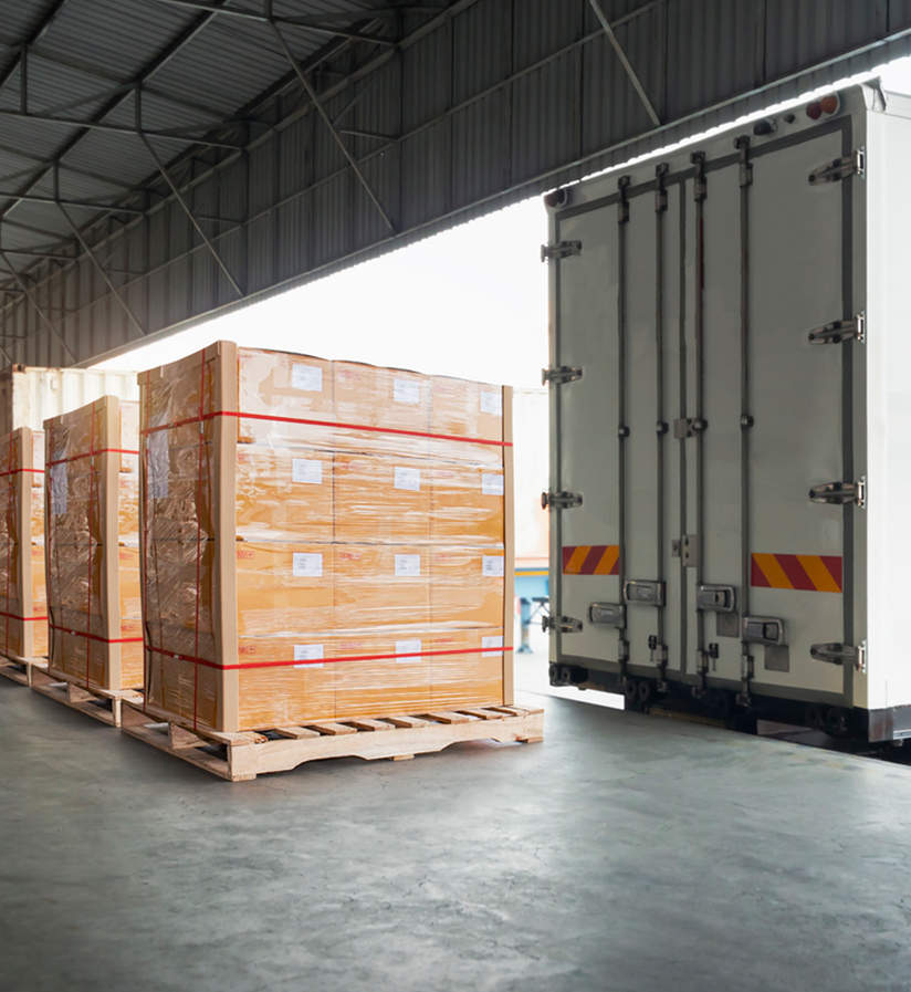 Three plastic wrapped shipments waiting to be loaded onto a semi truck.