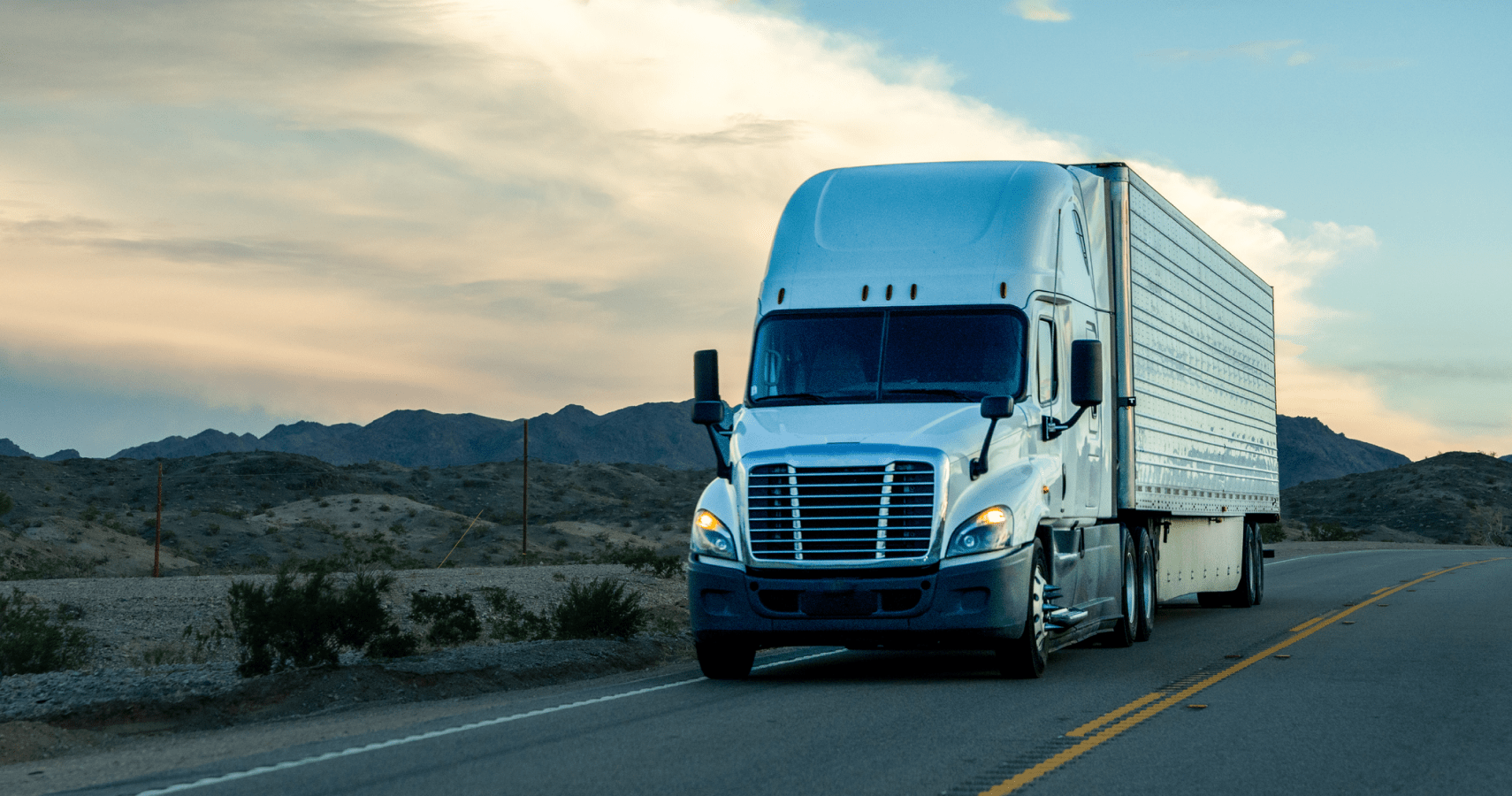 Semi truck driving down a rural highway.