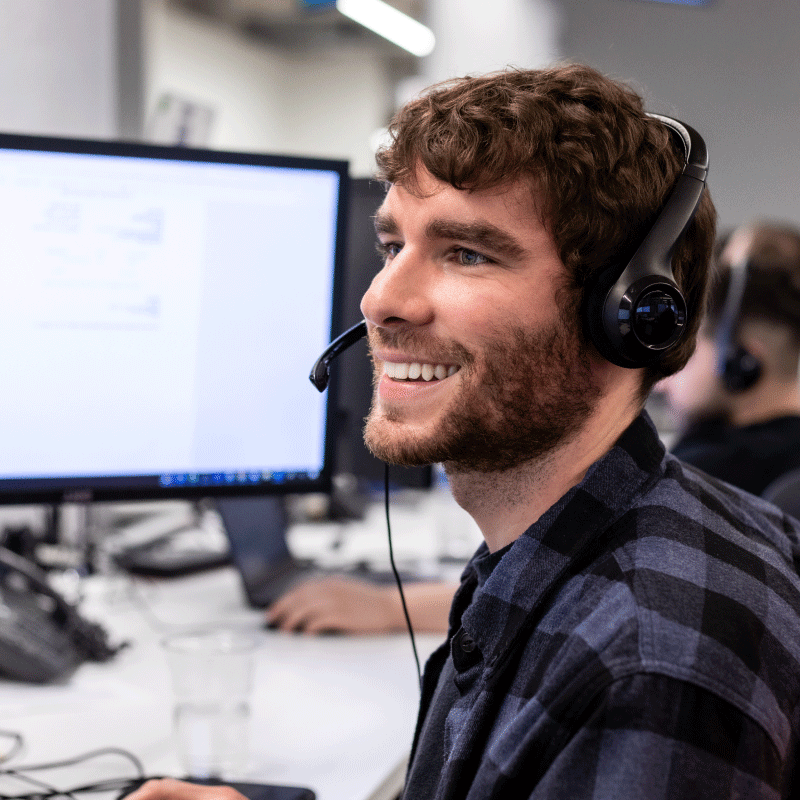 Echo employee sitting at desk talking over a headset.